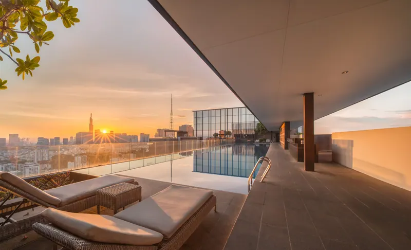 Hồ bơi tràn trên tầng thượng The Marq lúc bình minh, phía xa là Landmark 81